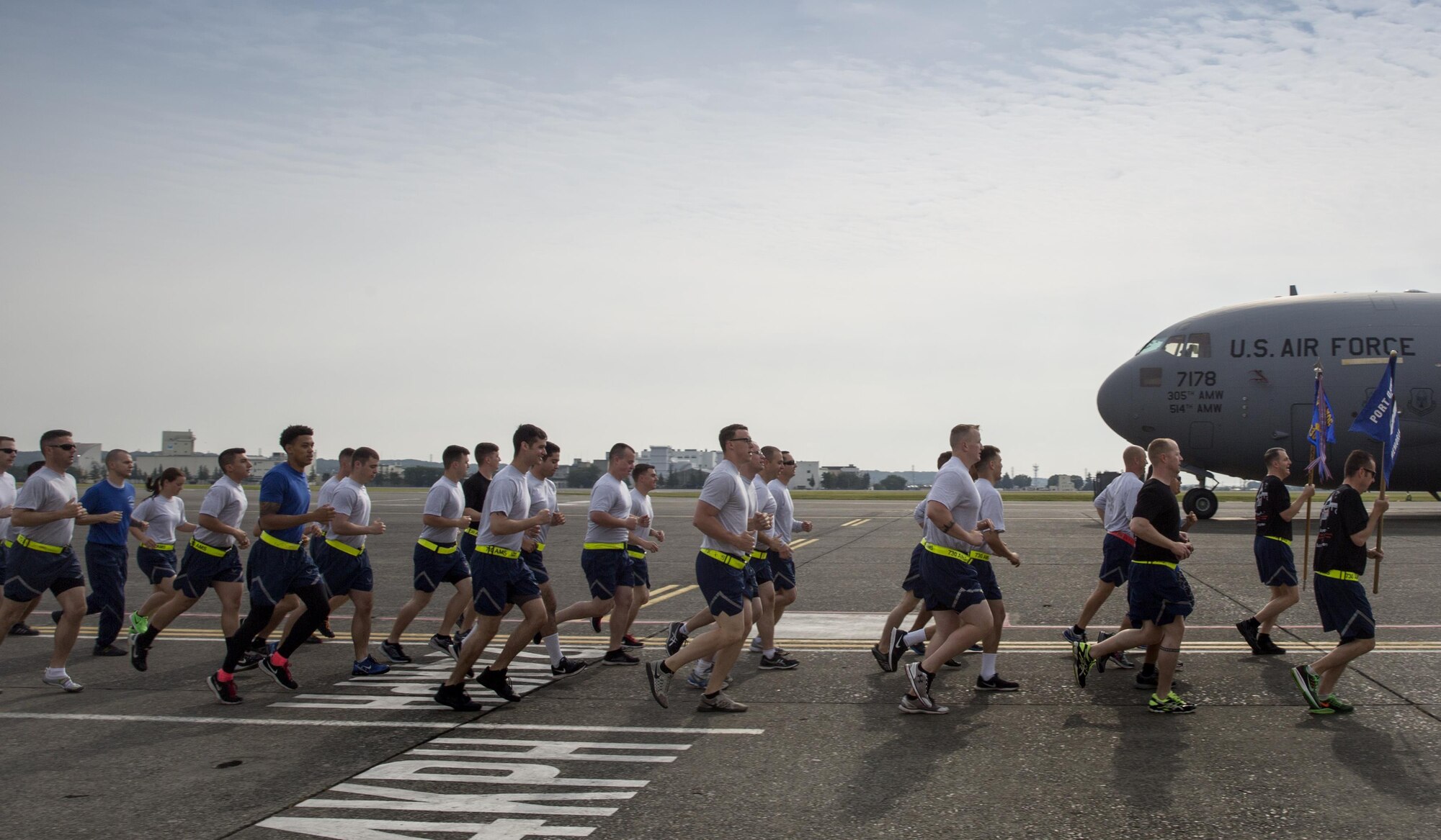 Yokota Airmen with the 515th Air Mobility Operations Group, 730th Air Mobility Command, and 374th Logistics Readiness Squadron run in a formation during the Port Dawg Memorial 5K Run at Yokota Air Base, Japan, May 20, 2016. “Port Dawg” is a nickname for aerial port members. This is the 3rd annual memorial run for the five fallen Airmen in the air transportation career field since 2015. (U.S. Air Force photo by Yasuo Osakabe/Released)