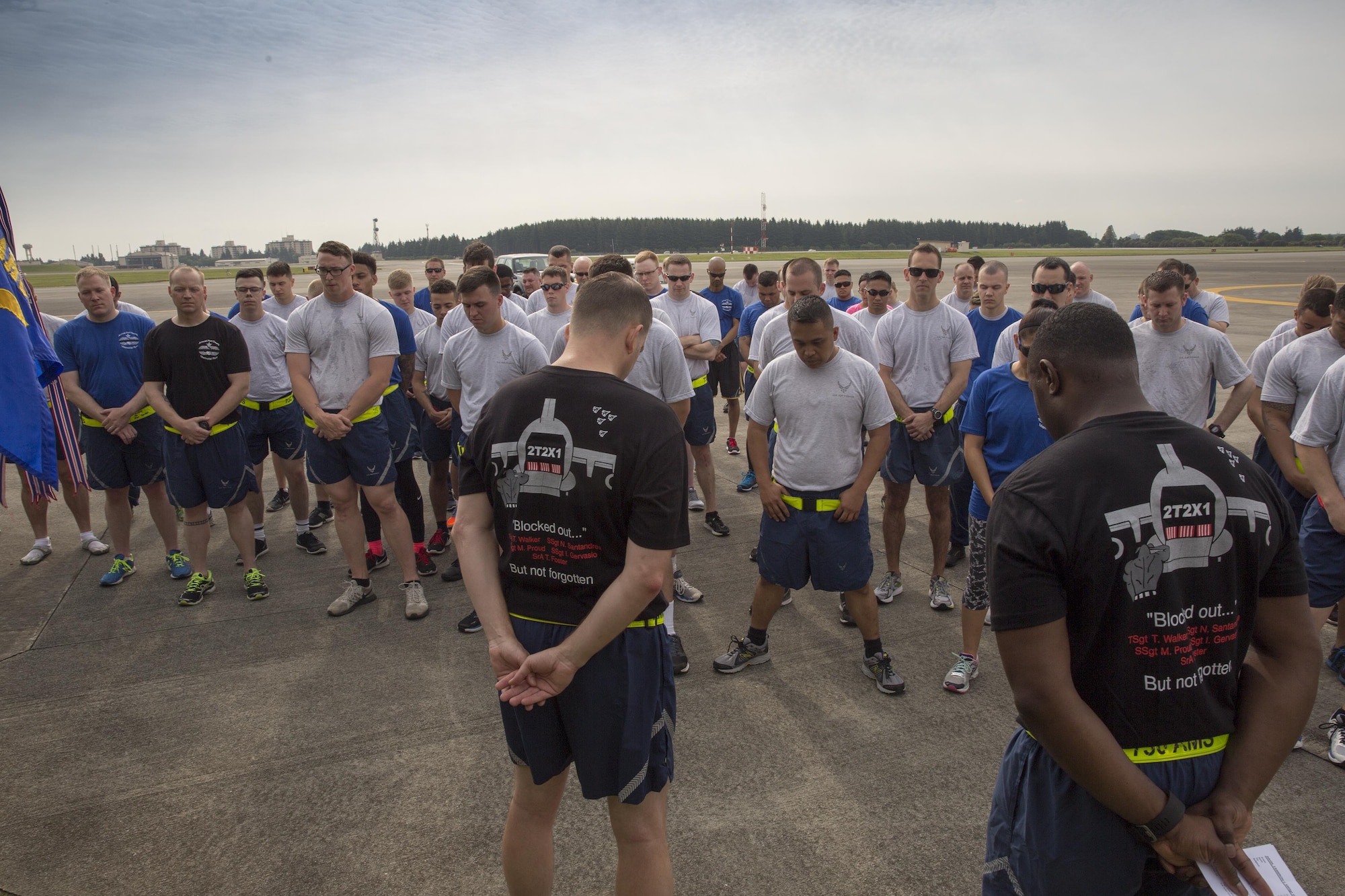 Airmen from the 515th Air Mobility Operations Group, 730th Air Mobility Squadron and 374th Logistics Readiness Squadron bow their heads during a moment of silence during the Port Dawg Memorial 5K Run at Yokota Air Base, Japan, May 20, 2016. The 730 AMS hosted the annual memorial run for the fallen Airmen in the Air Transportation career field in the past. (U.S. Air Force photo by Yasuo Osakabe/Released) 