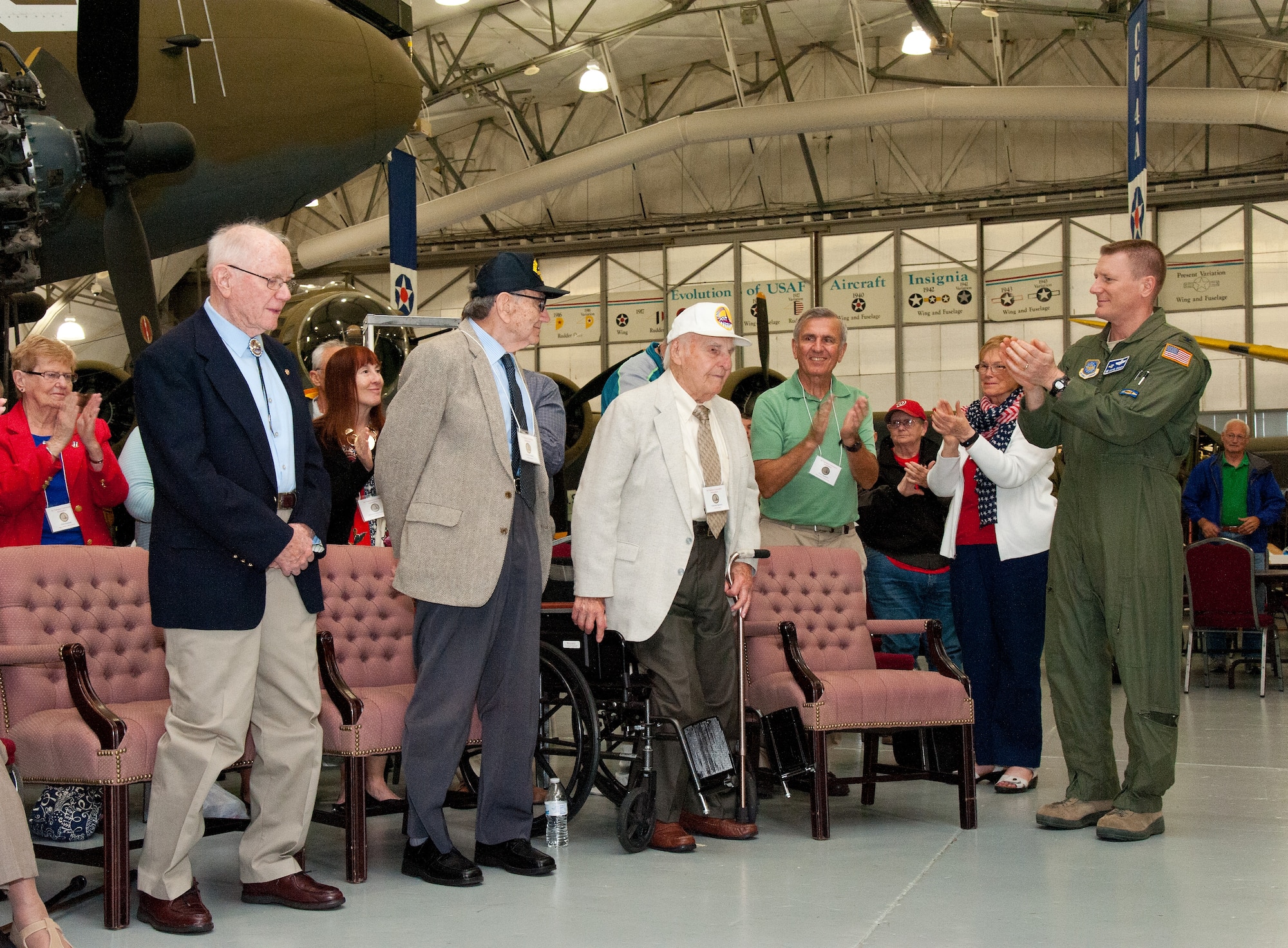 Col. Michael Grismer, 436th Airlift Wing commander, far right, as well as attendees, applaud former Air Transport Command members Ed Sipowicz, radio operator; George Scholfield, navigator; and Jack Kinyon, flight traffic clerk, right to left respectively, during an unveiling ceremony for the new ATC exhibit in the Air Mobility Command Museum, May 21, 2016, on Dover Air Force Base, Del. Grismer saluted the ATC veterans for their service and attendance. (U.S. Air Force photo/Roland Balik)
