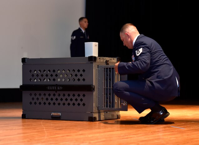 Tech. Sgt. Timothy Garrett, a 628th Security Forces Squadron military working dog handler, puts a leather leash and collar into a kennel during a memorial service for his former dog, Military Working Dog Akim/J375, at Joint Base Charleston, May 26, 2016. Akim went on several deployments and missions supporting the president, first lady and vice president of the United States. Akim also served the U.S. Secret Service before retiring in 2014. (U.S. Air Force photo/Airman Megan Munoz)