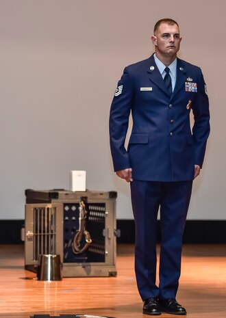 Tech. Sgt. Timothy Garrett, a 628th Security Forces Squadron military working dog handler, preforms Military Working Dog’s Last Call to Heel during a memorial service for his former dog, Military Working Dog Akim/J375, at Joint Base Charleston, May 26, 2016. Akim started his career as a single purpose dog, specializing in explosive detection and later received more training to become certified in patrols. (U.S. Air Force photo/Airman Megan Munoz)