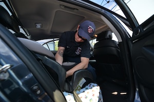 Brandon Young, Fort Eustis Fire Department firefighter, installs a car seat during a safety check event at Fort Eustis, Va., May 24, 2016. The fire department installed seats and covered proper installation procedures with Joint Base Langley-Eustis community members as a way to ensure safety of drivers and their passengers. (U.S. Air Force photo by Staff Sgt. Natasha Stannard)