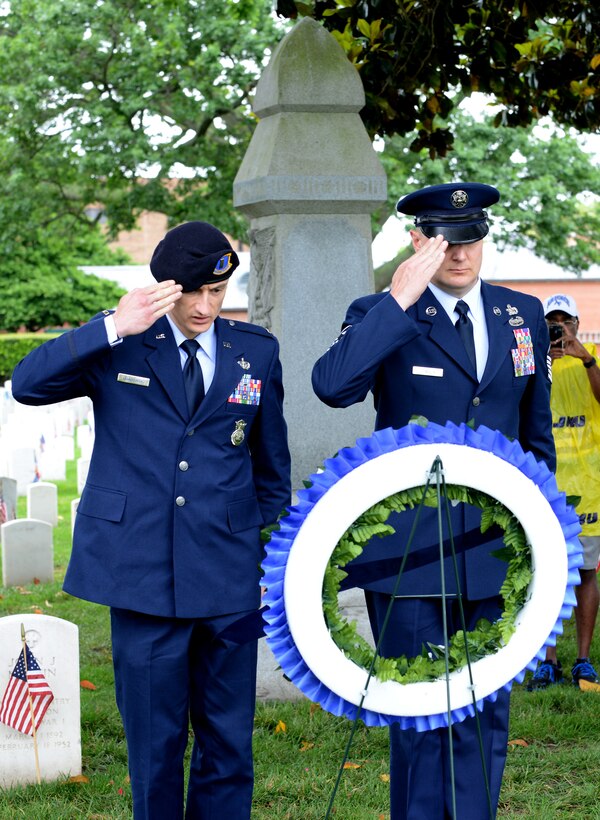 U.S. Air Force 2nd Lt. Sean Grabowski, officer-in-charge of police services assigned to the 633rd Security Forces Squadron, and Master Sgt. Richard Chwalik, first sergeant assigned to the 633rd SFS, salute a ceremonial wreath during a Memorial Day ceremony in Hampton, Va., May 30, 2016. During the ceremony, U.S. military personnel and local community members honored the fallen, prisoners of war and those missing in action who have served in conflicts across the world. (U.S. Air Force photo by Staff Sgt. Teresa J. Cleveland)
