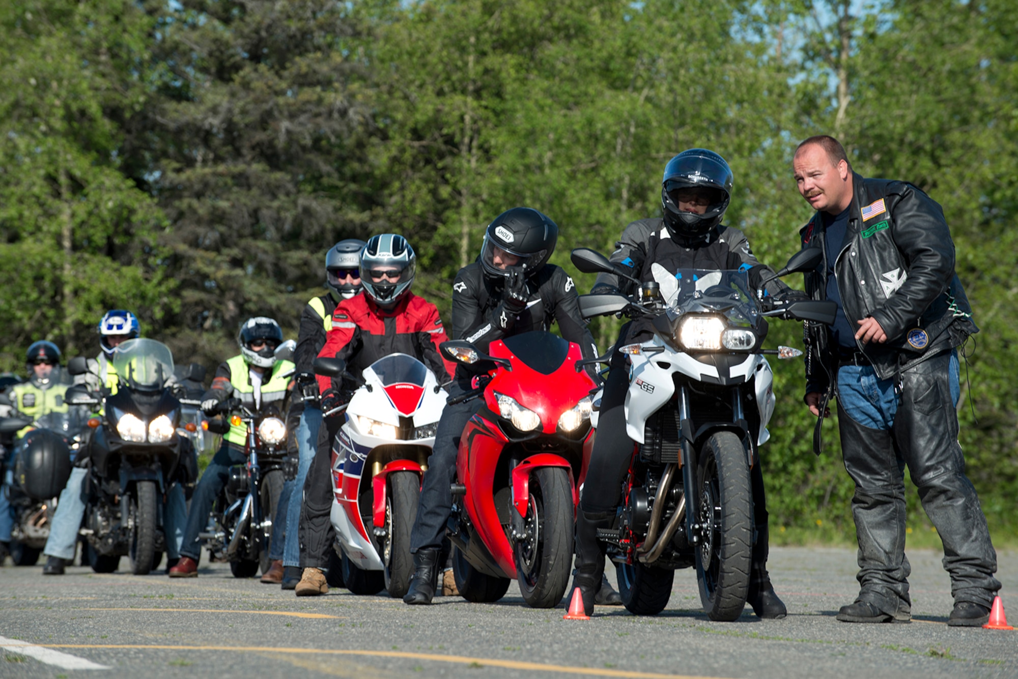 Fort Wainwright firefighter Heath Melvin offers some advice to Danielle Pineiro, who just learned to ride with her husband two days earlier, before her skills assessment at the motorcycle safety pad on Fort Richardson, May 26. The Joint Base Elmendorf-Richardson annual motorcycle safety ride is designed to connect new riders with experienced riders to foster mentor relationships and hone their skills together. (U.S. Air Force photo by Senior Airman Kyle Johnson)