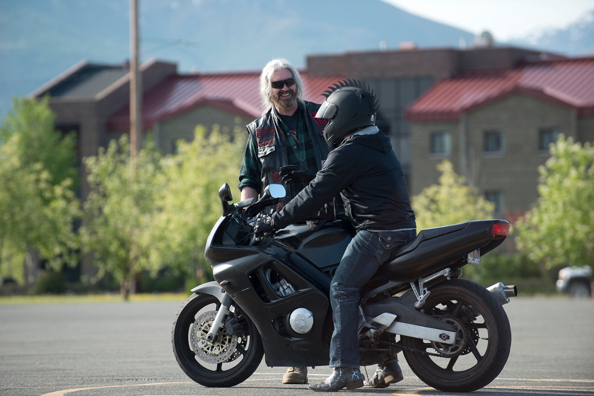 Motorcycle safety instructor Dan Havoc Coffey offers a laugh and a helpful tip to a rider during a skills assessment at the motorcycle safety pad on Fort Richardson, May 26. The Joint Base Elmendorf-Richardson annual motorcycle safety ride is designed to connect new riders with experienced riders to foster mentor relationships and hone their skills together. (U.S. Air Force photo by Senior Airman Kyle Johnson)