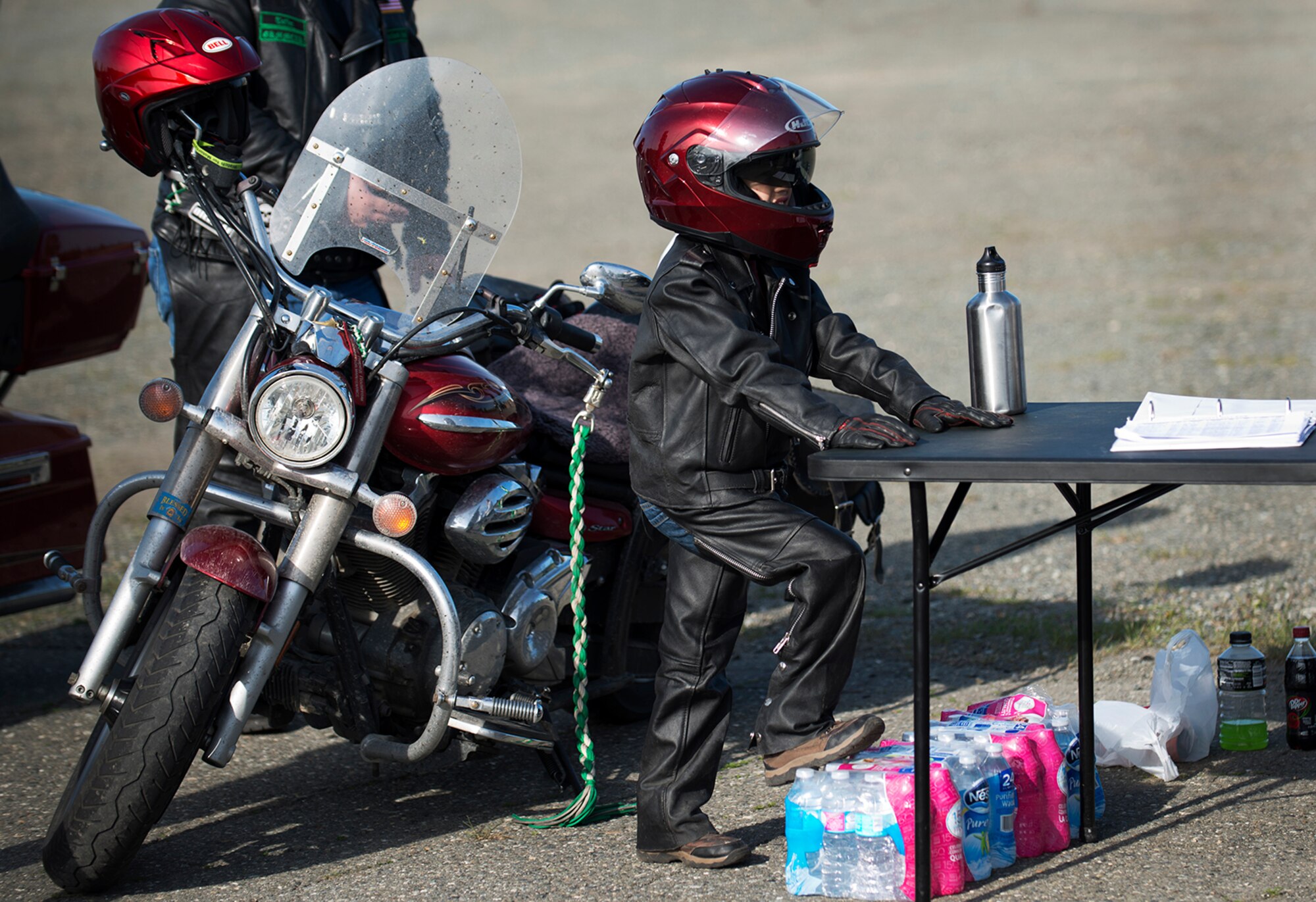 A.J. Melvin, son of Fort Wainwright firefighter Heath Melvin, waits by his father's motorcycle for the police escort to arrive at the motorcycle safety pad on JBER-Richardson, May 26. The Joint Base Elmendorf-Richardson annual motorcycle safety ride is designed to connect new riders with experienced riders to foster mentor relationships and hone their skills together. (U.S. Air Force photo by Senior Airman Kyle Johnson)
