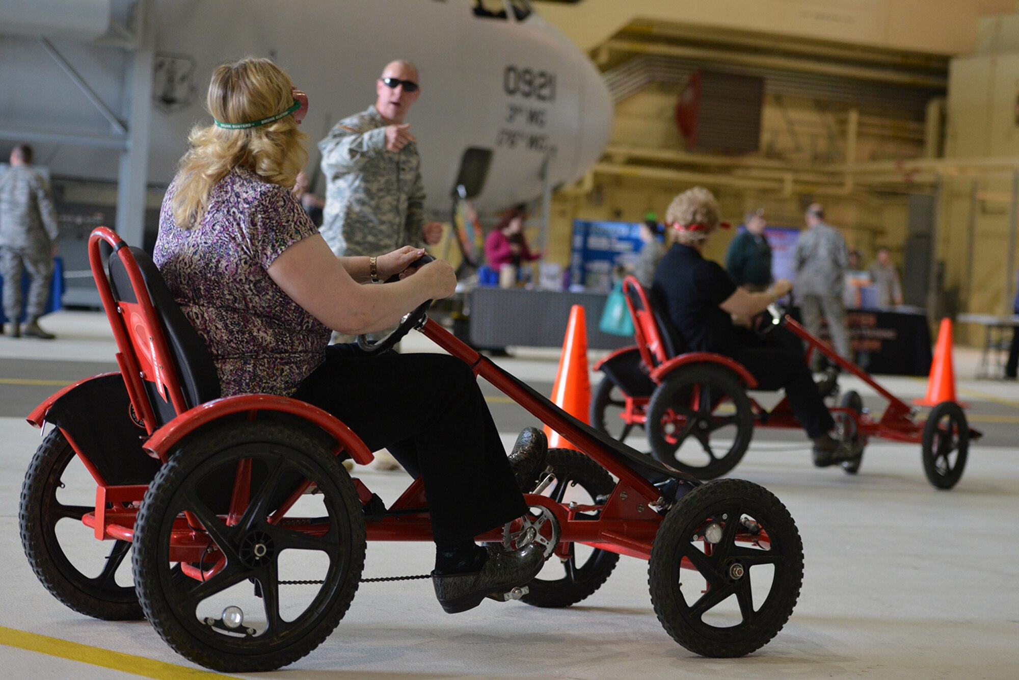 Safety fair attendees drive pedal carts wearing beer-goggles to simulate the impaired vision alcohol causes in Hangar 1 on Joint Base Elmendorf Richardson, Alaska, May 26, 2016. According for the Centers for Disease Control and Prevention, in the U.S. 28 people die in motor vehicle crashes that involve an alcohol-impaired driver each day. (U.S. Air Force photo by Airman 1st Class Javier Alvarez)