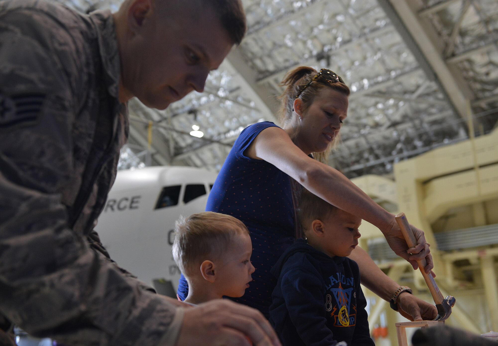 Air Force Staff Sgt. Johnathan Murphy, 673d Air Base Wing Safety Office occupational safety technician, builds a bird house with his family at the safety fair in Hangar 1, on JBER, Alaska, May 26, 2016. Vendors from multiple organizations provided workplace and recreational safety information for base personnel before the summer season. (U.S. Air Force photo by Airman 1st Class Javier Alvarez)