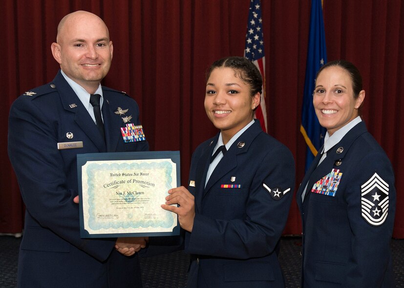 Col. David R. Dunklee, left, installation commander, and Hanscom Air Force Base Command Chief Master Sgt. Patricia L. Hickey present Airman Nia J. McClearn, 66th Medical Squadron dental technician, a certificate during the monthly enlisted promotion ceremony at the Minuteman Commons May 31. The monthly enlisted promotion ceremony, generally held the last duty day of the month, gives the Hanscom community a chance to recognize enlisted Airman selected for promotion. (U.S. Air Force photo by Jerry Saslav)