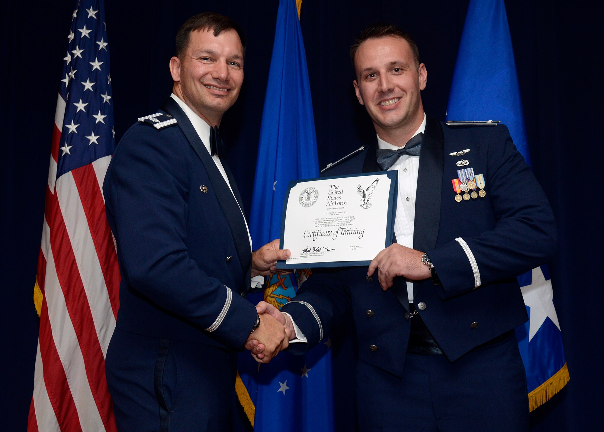 1st Lt. John Lorbiecki receives his graduation certification during the 310th Fighter Squadron Pilot B-Course graduation ceremony, May 20, at Luke Air Force Base, Ariz.