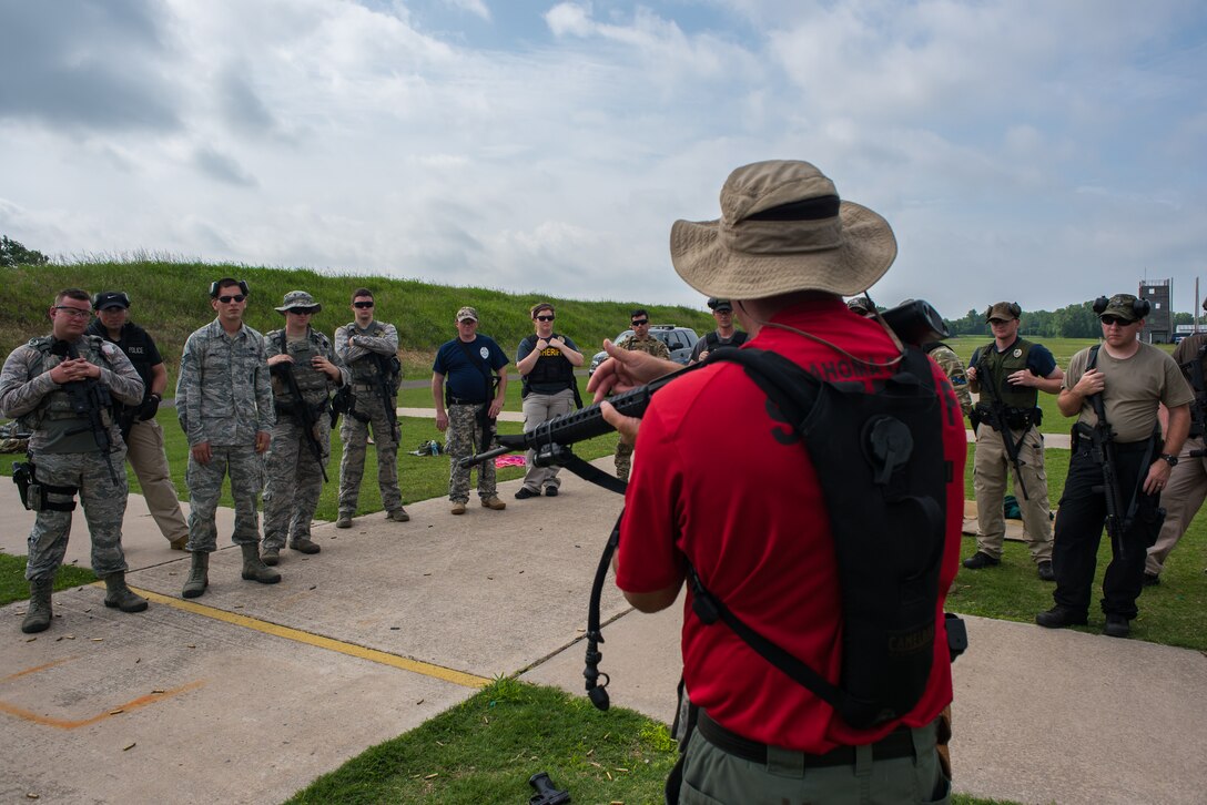 Oklahoma County Sheriff’s Office Sgt. Jim Lilly, a staff training deputy, discusses proper form while transitioning between firearms at the Oklahoma County Sheriff's Office Training Center in Oklahoma City, May 26, 2016. Four Will Rogers Air National Guard Base Airmen joined local policing agencies for weapons training, May 24-26. The Oklahoma Country Sheriff's Office led the training to enhance communication and compatibility between various Oklahoma law enforcement groups. (U.S. Air National Guard photo by Senior Airman Tyler Woodward)