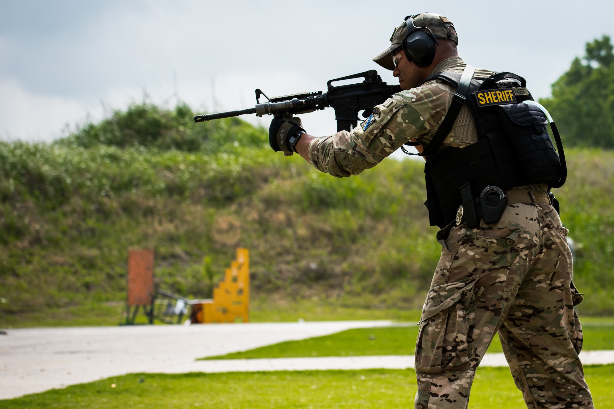 Oklahoma Army National Guard Chief Warrant Officer 2 Tyrie Haught, a Chinook pilot at the 2-149 General Support Aviation Battalion in Lexington, Okla., and also a deputy sheriff for Oklahoma County, fires a weapon during a transition exercise at the Oklahoma County Sheriff's Office Training Center in Oklahoma City, May 26, 2016. Four Will Rogers Air National Guard Base Airmen joined local policing agencies for weapons training, May 24-26. The Oklahoma Country Sheriff's Office led the training to enhance communication and compatibility between various Oklahoma law enforcement groups. (U.S. Air National Guard photo by Senior Airman Tyler Woodward)