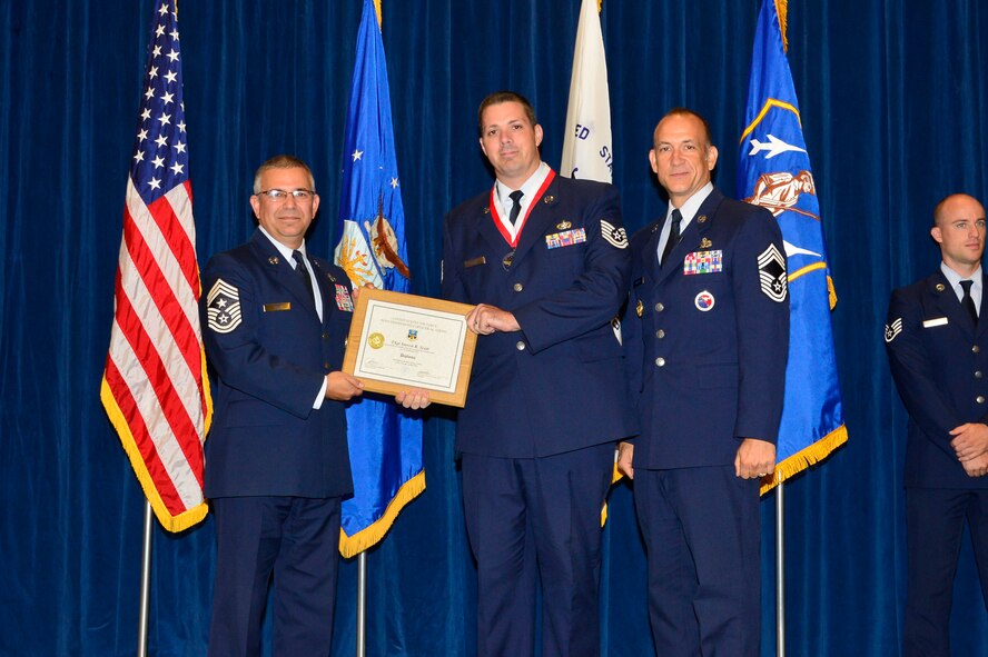 Tech. Sgt. Steven Scott, right, receives the Distinguished Graduate Award for NCO academy class 16-4 from Chief Master Sgt. Timothy Horn, Command Chief Master Sgt. of Air University here, May 27, 2016, at the I.G. Brown Training and Education Center in Louisville, Tenn. The distinguished graduate award is presented to the top 10 percent of the class. (U.S. Air National Guard photo by Master Sgt. Jerry D. Harlan/Released)