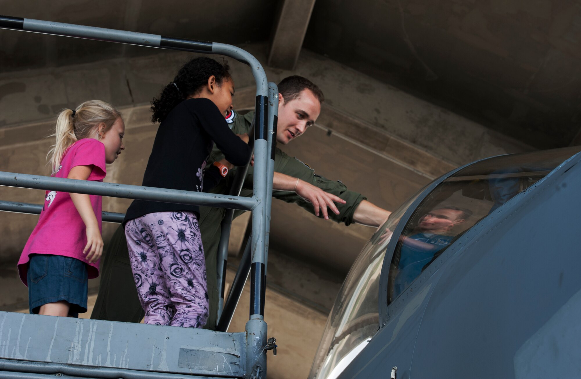 U.S. Air Force 1st Lt. Matthew Selby, 44th Fighter Squadron pilot, shows the cockpit of an F-15 Eagle to Taylor Sheidy and Erica Weekly, Bechtel Elementary School first grade students, May 16, 2016, at Kadena Air Base, Japan. Students were able to see the controls that the pilots use when operating the aircraft. The cockpit includes displays for aircraft systems and weapons management. (U.S. Air Force photo by Airman 1st Class Lynette M. Rolen)