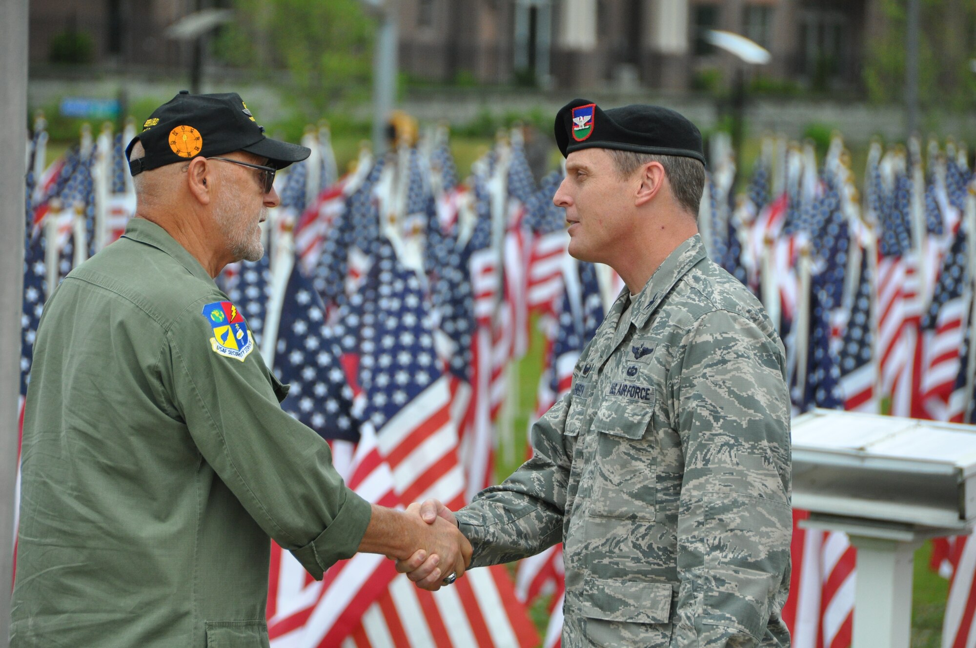 Colonel Christopher Jensen, Commander 18th Air Support Operations Group, Air Combat Command, speaks with veteran after the conclusion of this year’s 9th annual Field of Honor Ceremony, May 21, 2016. The Field of Honor displays hundreds of flags in recognition of the ultimate sacrifice military members have paid in duty and service to our country. This sacred field pays tribute to their stories of service, honor and heroism. (Air Force photo by Allison Janssen)