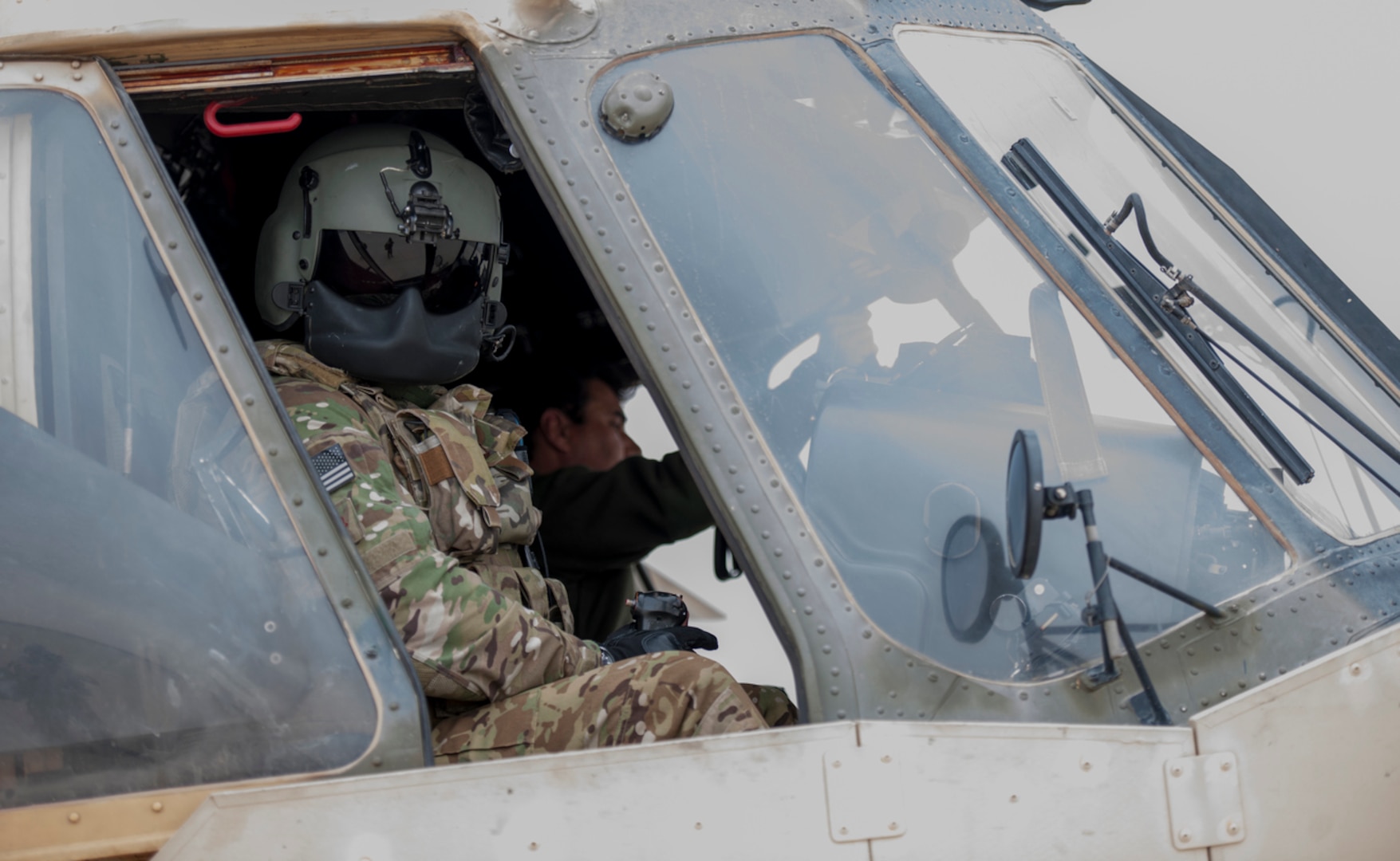 An Afghan Air Force pilot powers down an Mi-17 helicopter as a Train Advise Assist Command-Air Mi-17 Air Advisor looks out a cockpit window after a training mission at Kandahar Airfield, Afghanistan, earlier this ye. Members of the 441st Air Expeditionary Advisory Squadron at KAF worked with AAF pilots on take-off, landing and emergency procedures. (U.S. Air Force Photo by Tech. Sgt. Robert Cloys)