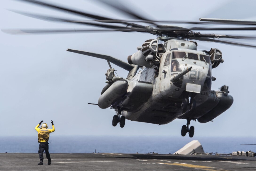 Petty Officer 3rd Class Demetri Cornett signals the pilot of a CH-53S Super Stallion to take off from the flight deck of amphibious assault ship USS Boxer in the Gulf of Aden, May 31, 2016. Cornett is an aviation boatswain's mate. The Boxer is supporting security operations and theater security cooperation efforts in the U.S. 5th Fleet area of operations. Navy photo by Petty Officer 2nd Class Debra Daco