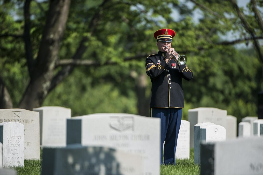 A bugler assigned to the U.S. Army Band, “Pershing’s Own,” plays taps during a graveside service at Arlington National Cemetery in Arlington, Va., June 1, 2016. Army photo by Rachel Larue