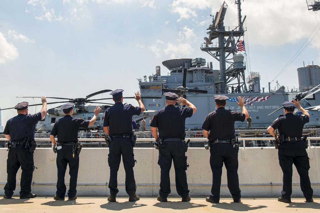 New York City police officers wave goodbye to USS Bataan sailors as the ship departs the Manhattan Cruise Terminal, May 31, 2016, after participating in Fleet Week New York. More than 4,500 sailors, Marines and Coast Guardsmen descended upon the city for the  event. Navy photo by Petty Officer 1st Class Gina K. Danals