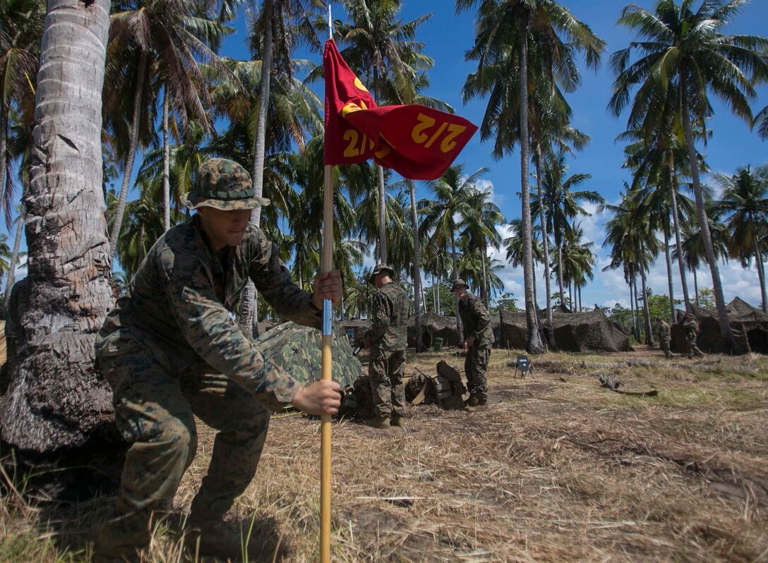 TANDUO BEACH, MALAYSIA (May 30, 2016) – U.S. Marine Corps Lance Cpl. Dante Policicchio, a rifleman with Easy Company, Battalion Landing Team, 2nd Battalion, 2nd Marines sticks the company’s guidon into the ground after an amphibious transition from ship to shore.The Marines are embarked with Sailors aboard the USS Ashland (LSD 48) in support of exercise Cooperation Afloat Readiness and Training. CARAT is a series of annual, bilateral maritime exercises between the U.S. Navy, U.S. Marine Corps and the armed forces of nine partner nations to include Bangladesh, Brunei, Cambodia, Indonesia, Malaysia, Singapore, the Philippines, Thailand and Timor-Leste.The Ashland is assigned to U.S. 7th Fleet. (U.S. Navy photo by Lance Cpl. Carl King Jr/. Released)