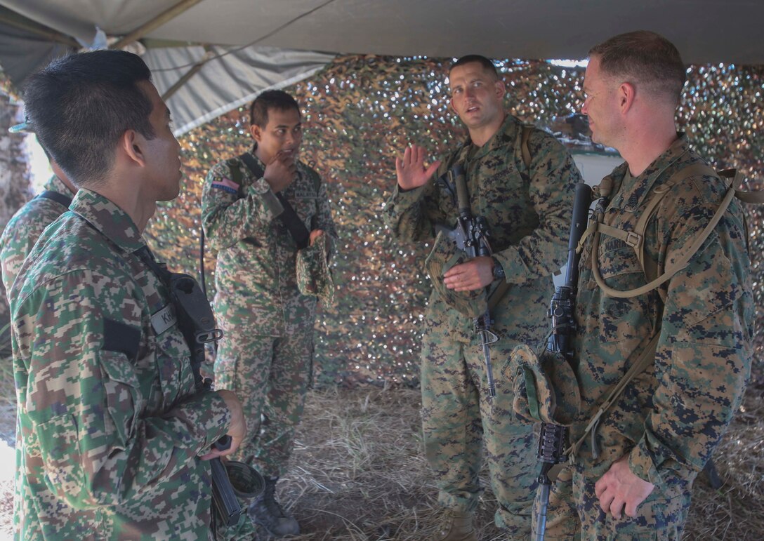 TANDUO BEACH, MALAYSIA (May 30, 2016) – U.S. Marine Corps First Sgt. Benjamin Zeigler, the company first sergeant assigned to Easy Company, Battalion Landing Team, 2nd Battalion, 2nd Marines, Middle right, explains the capabilities of a Marine Corps rifle squad to service members of the Royal Malay Army after an amphibious transition from ship to shore. The Marines are embarked with U.S. Sailors aboard the USS Ashland (LSD 48) in support of exercise Cooperation Afloat Readiness and Training. CARAT is a series of annual, bilateral maritime exercises between the U.S. Navy, U.S. Marine Corps and the armed forces of nine partner nations to include Bangladesh, Brunei, Cambodia, Indonesia, Malaysia, Singapore, the Philippines, Thailand and Timor-Leste.The Ashland is assigned to the U.S. 7th Fleet. (U.S. Navy photo by Lance Cpl. Carl King Jr/. Released)
