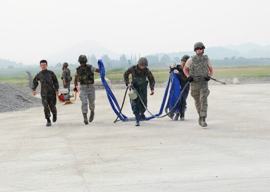 Members of the 8th Civil Engineer Squadron from Kunsan Air Base, Republic of Korea, talk with RoK Air Force counterparts during an Airfield Damage Repair bilateral training scenario at Gwangju Air Base, RoK on June 1, 2016. The training is part of Pacific Unity, a bilateral training exercise designed to enhance interoperability and build partnership capacity in the Indo-Asia Pacific region. (U.S. Air Force photo/Staff Sgt. Chelsea Browning)