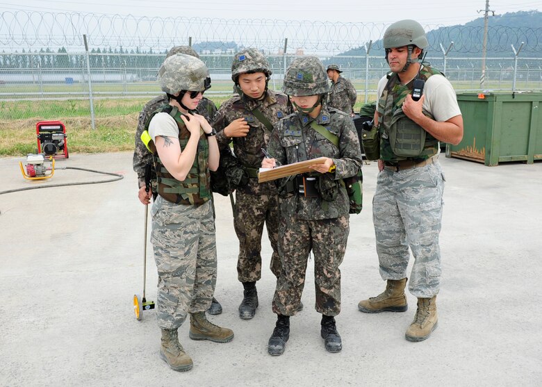 Members of the 8th Civil Engineer Squadron from Kunsan Air Base, Republic of Korea, talk with RoK Air Force counterparts during an Airfield Damage Repair bilateral training scenario at Gwangju Air Base, RoK on June 1, 2016. The training is part of Pacific Unity, a bilateral training exercise designed to enhance interoperability and build partnership capacity in the Indo-Asia Pacific region. (U.S. Air Force photo/Staff Sgt. Chelsea Browning)