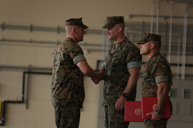 Col. Daniel Shipley, commanding officer of Marine Aircraft Group (MAG) 12, congratulates Lt. Col. Matthew W. Stover, commanding officer of Marine Aerial Refueler Transport Squadron (VMGR) 152, on a successful tour of commanding officer during a change of command ceremony at Marine Corps Air Station Iwakuni, Japan, May 27, 2016. Stover served as the VMGR-152 commanding officer for two years and successfully transition the squadron from Okinawa to Iwakuni in 2014. (U.S. Marine Corps photo by Cpl. Nicole Zurbrugg/Released)