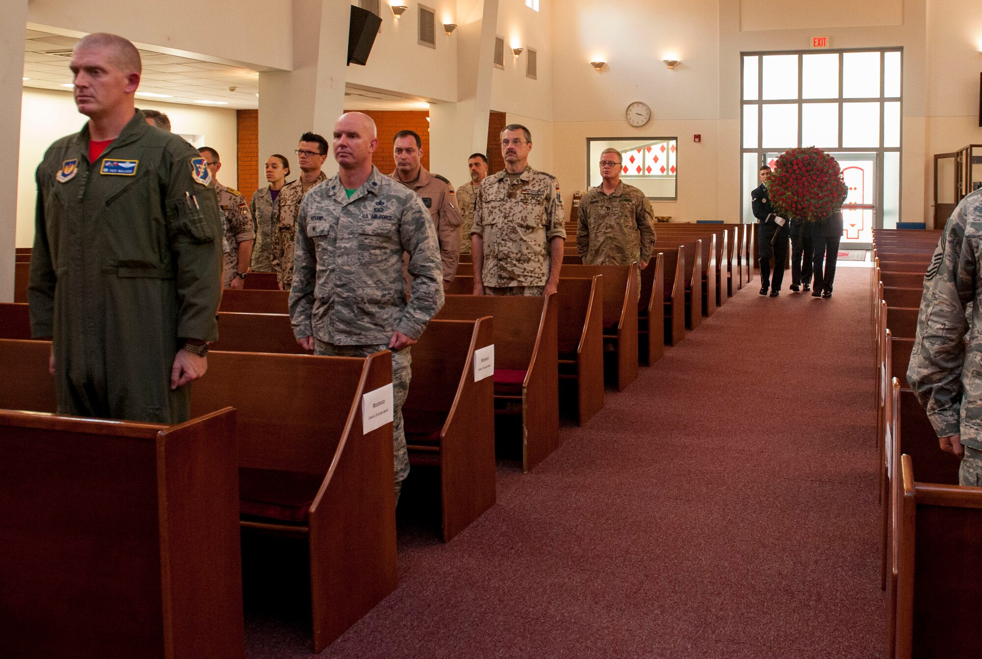 Audience members stand at attention while members of the base honor guard bring forth a wreath of flowers to be laid out during a Memorial Day remembrance ceremony held at the base chapel May 27, 2016, at Incirlik Air Base, Turkey. The ceremony was a time to reflect on those lost during past and current conflicts. (U.S. Air Force photo by Staff Sgt. Jack Sanders/Released)
