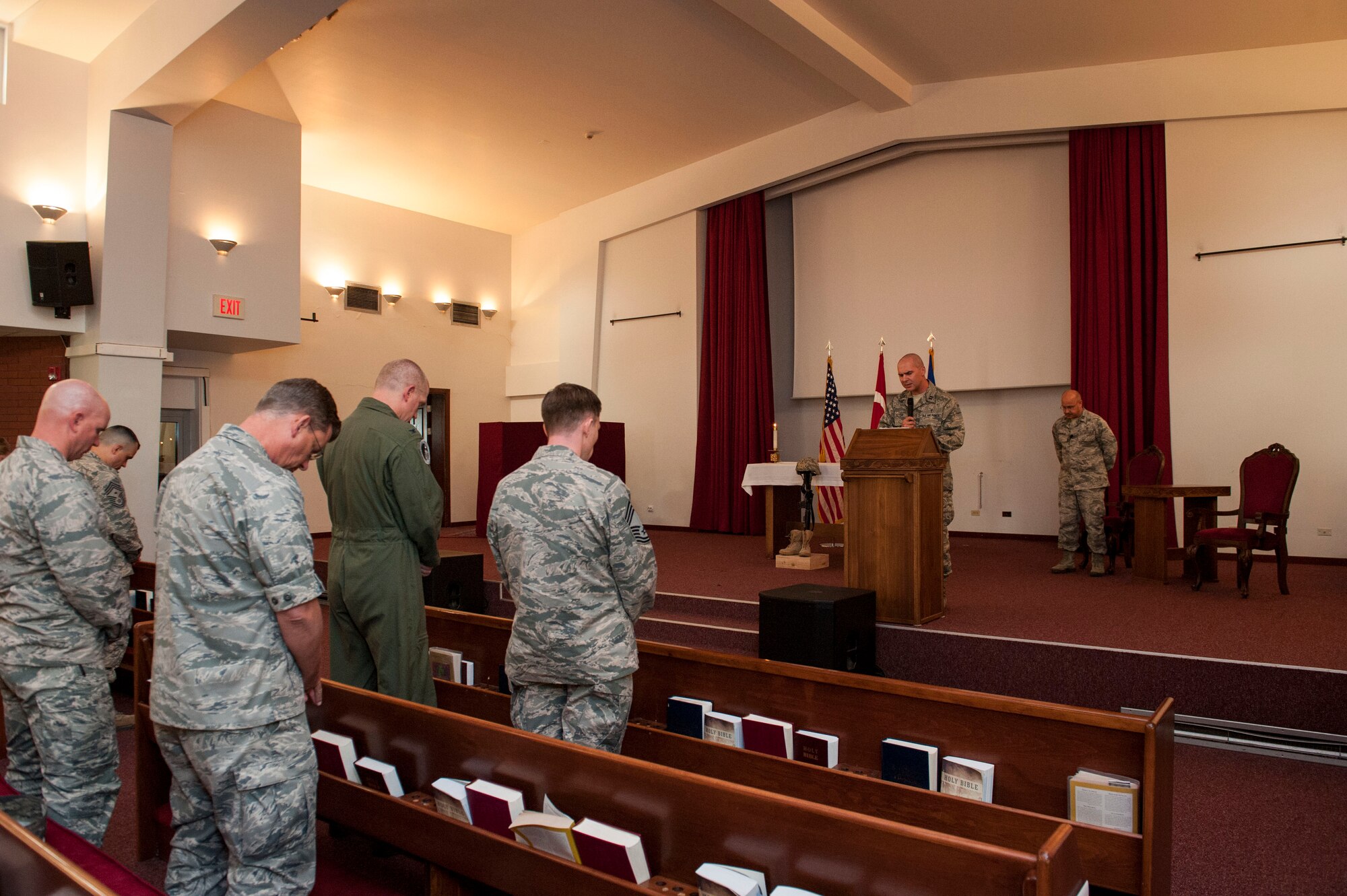 Leadership bows their heads as U.S. Air Force Chaplain (Capt.) David Merrifield, 39th Air Base Wing, gives the invocation during a Memorial Day remembrance ceremony held at the base chapel May 27, 2016 at Incirlik Air Base, Turkey. Merrifield spoke on remembering the shoulders we stand on as we continue today’s missions. (U.S. Air Force photo by Staff Sgt. Jack Sanders/Released)