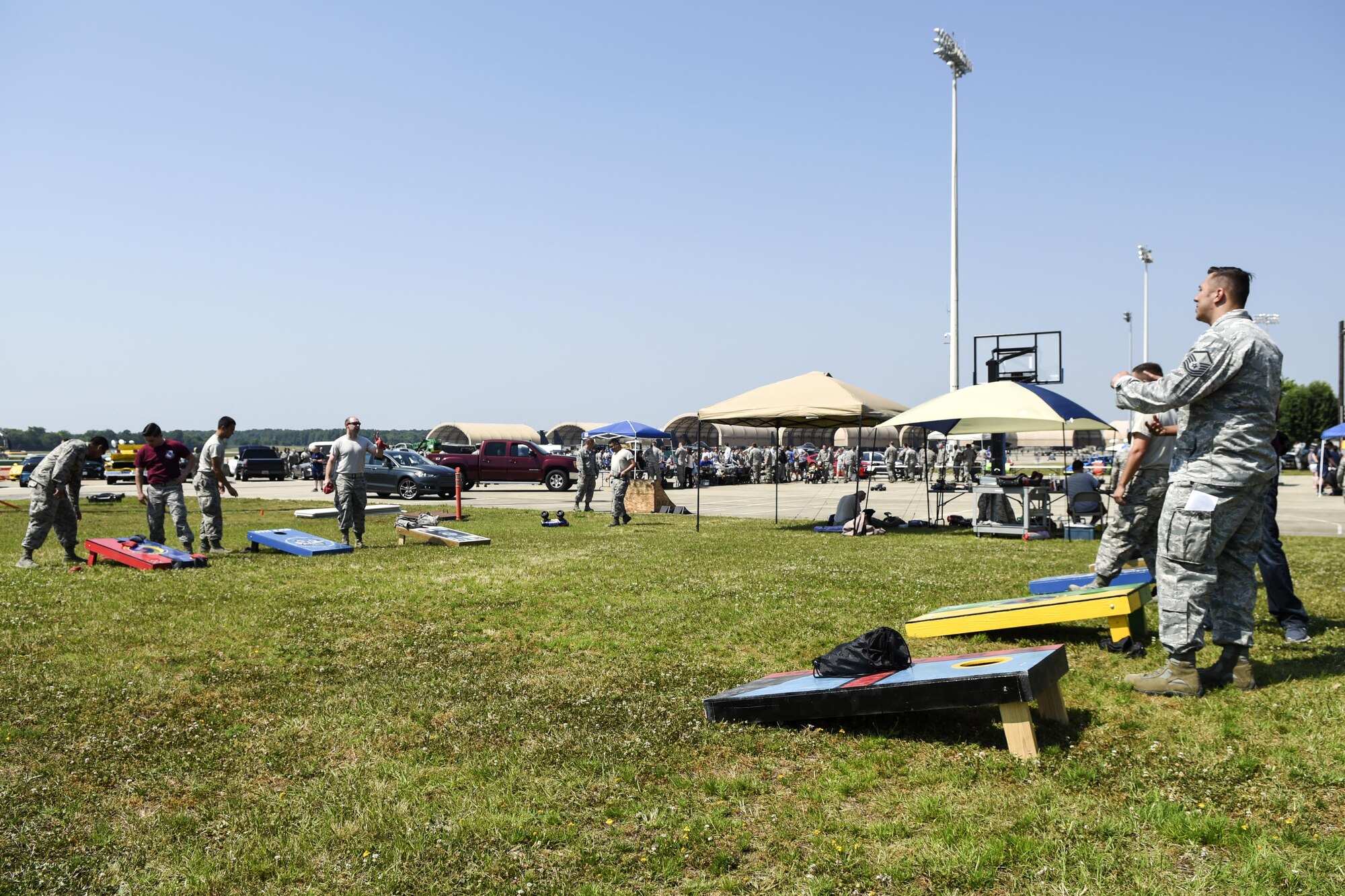 Airmen play a round of corn hole during a Make It Better Club Day event, May 26, 2016, at Seymour Johnson Air Force Base, North Carolina. More than 3,000 Airmen attended the MIB Club Day, which promotes a way for Airmen with diverse interests and ideas to collaborate, create events, make connections, develop leadership skills and receive opportunities to improve themselves and the base. (U.S. Air Force photo by Airman Shawna L. Keyes/Released)       