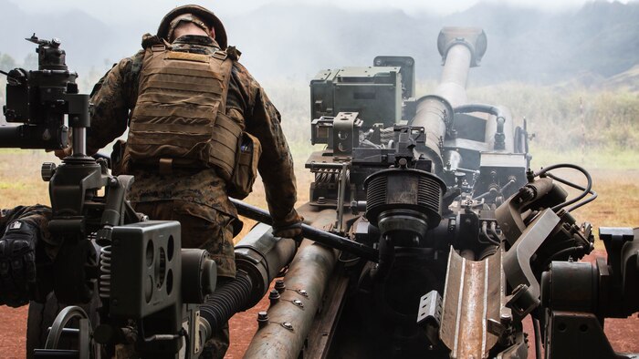 A Marine from Alpha battery, 1st Battalion, 12th Marine Regiment, “Kings of Battle,” cleans the cover of an M777 Lightweight 155mm howitzer during Spartan Fury, an annual pre-deployment exercise, aboard the Schofield Range Facility on May 4th, 2016.  Spartan Fury is one of three annual battalion level exercises to help improve sustainment training for future deployments. The objective of this five-day exercise is to support 3rd Regiment by providing direct and indirect artillery strikes. 