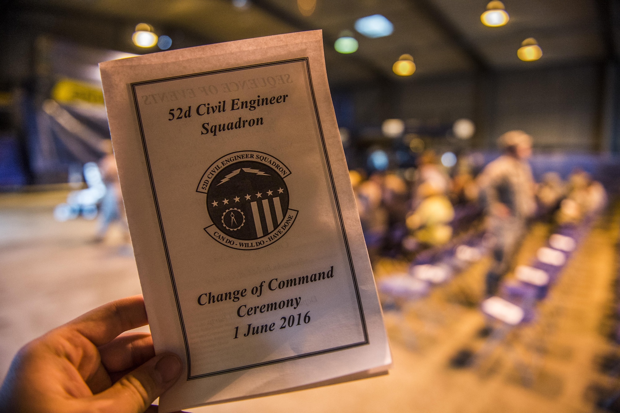 A brochure is held before the start of the 52nd Civil Engineer Squadron change of command ceremony at Spangdahlem Air Base, Germany, June 1, 2016. U.S. Air Force Col. Joe McFall, 52nd Fighter Wing commander, exchanged command of the 52nd CES from U.S. Air Force Lt. Col. Christopher Meeker, former 52nd CES commander, to U.S. Air Force Lt. Col. Ryan Crowley, incoming 52nd CES commander. (U.S. Air Force photo by Senior Airman Luke Kitterman/Released)