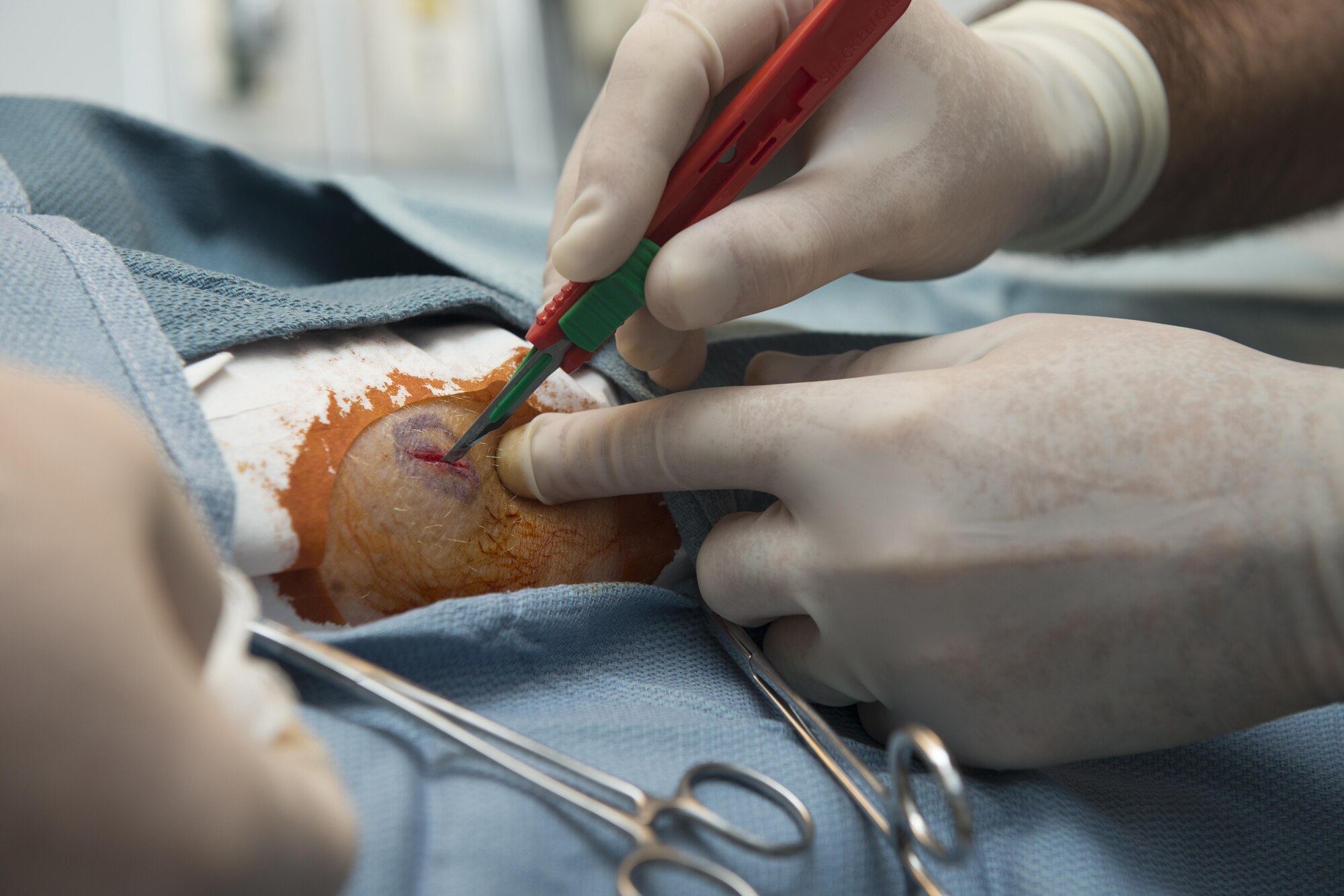 U.S. Air Force Col. Christopher Hayes, 39th Medical Group medical staff chief, makes an incision on the arm of U.S. Air Force Col. John Walker, 39th Air Base Wing commander, May 19, 2016, at Incirlik Air Base, Turkey. An incision was made to create a pathway surgeons can use to access the problematic area. (U.S. Air Force photo by Senior Airman John Nieves Camacho/Released)