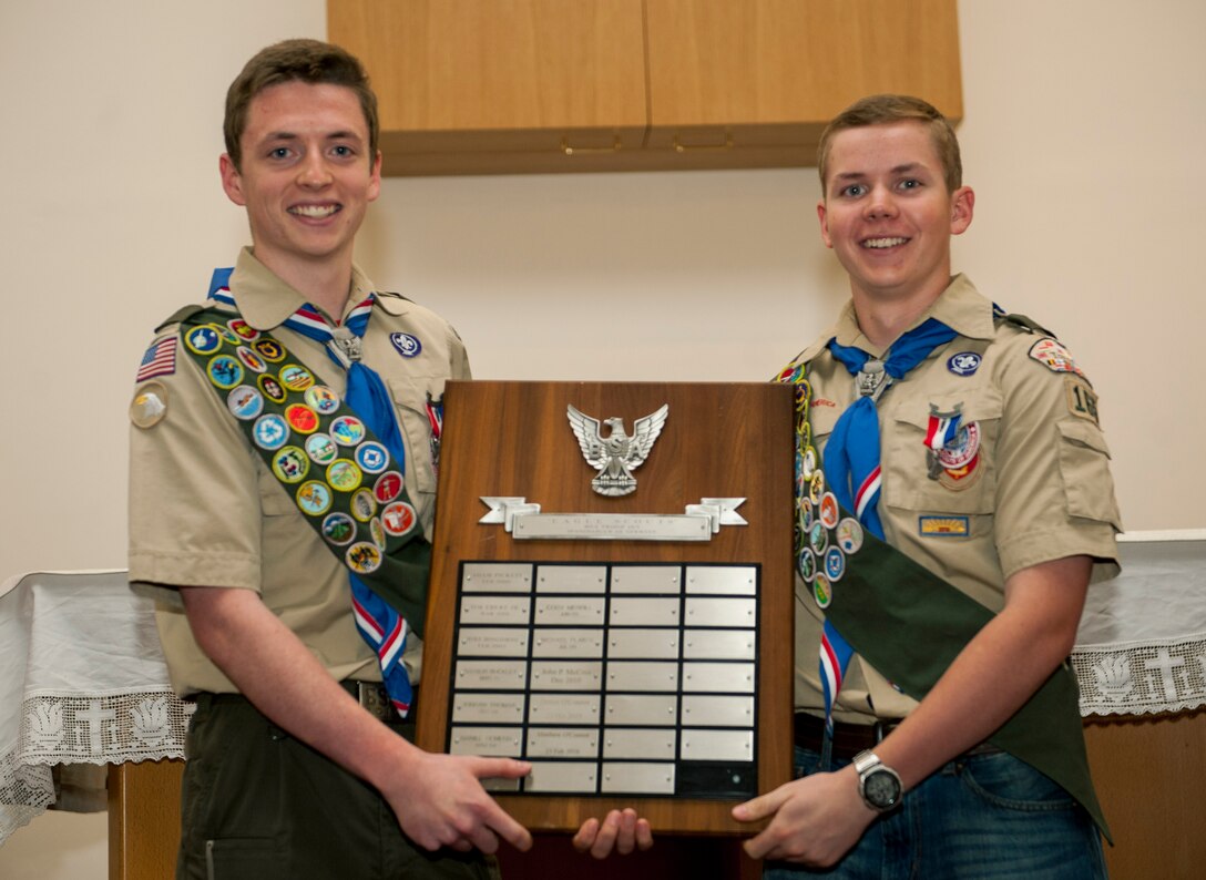 Daniel O’Connor, left, and Matthew O’Connor, both Boy Scouts of America Troop 165 Eagle Scouts, hold up the Eagle Scout recognition board during a ceremony in the base chapel at Spangdahlem Air Base, Germany, May 18, 2016. BSA Troop 165 added Daniel and Matthew O’Connors to a plaque listing the names of those who earned the top rank from their troop. (U.S. Air Force photo by Airman 1st Class Timothy Kim/Released)