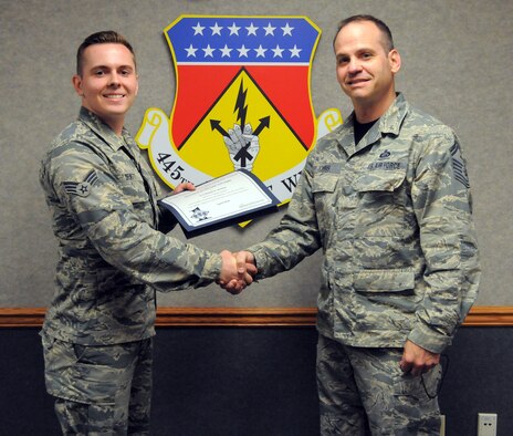 Senior Airman Daniel DeWitt, 445th Force Support Squadron client system technician, is presented the Wright-Patterson Reserve First Sergeant's Council Diamond Sharp Award by Senior Master Sgt. Anthony Johns, 445th FSS first sergeant, during a presentation May 14, 2016. (U.S. Air Force photo/Tech. Sgt. Anthony Springer)