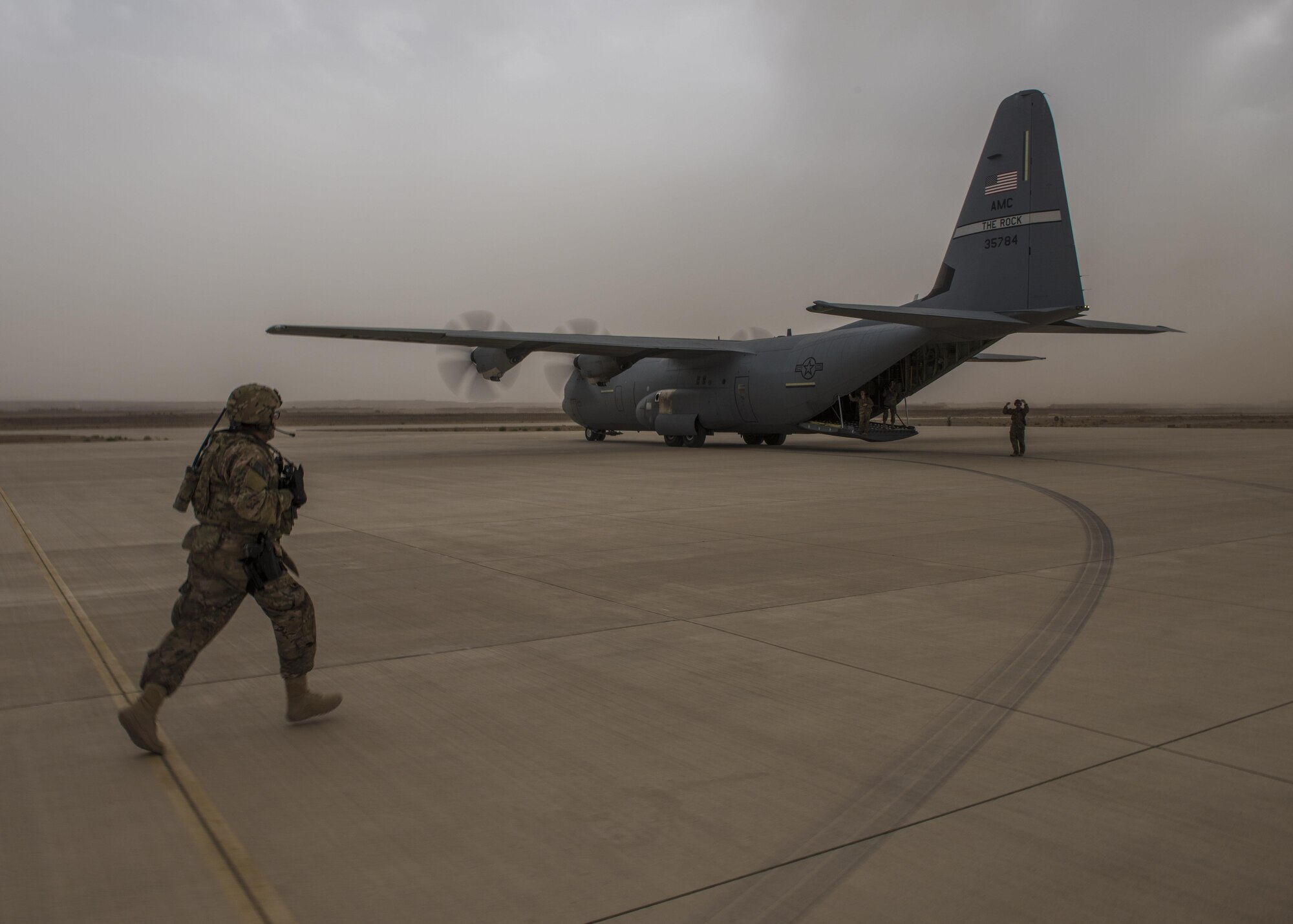 Staff Sgt. Jesus Mora, 455th Expeditionary Security Forces Squadron fly away security team lead, runs toward a C-130J Super Hercules after it executed a combat cargo drop, Multinational Base Tarin Kowt, Afghanistan, June 1, 2016. FAST members are responsible for protecting aircraft, military members and cargo during routine stops at unsecure airfields. (U.S. Air Force photo by Senior Airman Justyn M. Freeman)