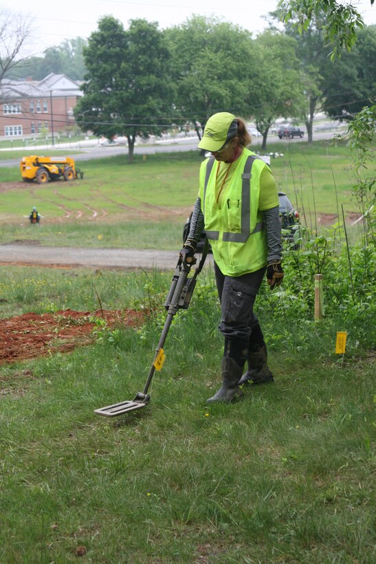 Reida Johnson, a technician with Tetra Tech, uses a metal detector to scan for buried munitions in the area aboard Marine Corps Base Quantico known as UXO 21 May 12. Before the new middle/high school can be built here, the site must cleared of potential unexploded ordnance.