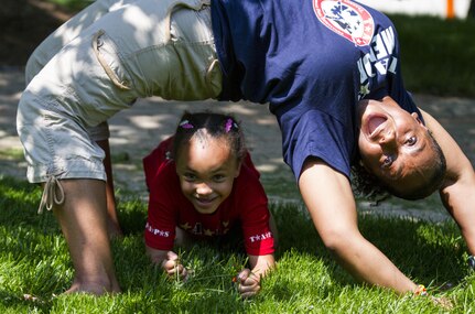 A Tragedy Assistance Program for Survivors (TAPS) mentor does gymnastics with her mentee during the National Military Survivor Seminar and Good Grief Camp in Washington, D.C., during Memorial Day weekend on May 27. TAPS is an organization that provides support to people who are affected by the death of a military service member. (U.S. Army photo by Spc. Victoria Friend)