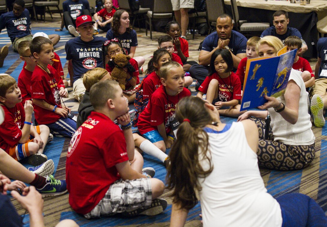 Children listen to a book being read by a volunteer working with the Tragedy Assistance Program for Survivors (TAPS) during the National Military Survivors Seminar and Good Grief Camp organized for those who lost family members who served in the military in Crystal City, Va., on May 28. (U.S. Army photo by Spc. Victoria Friend)