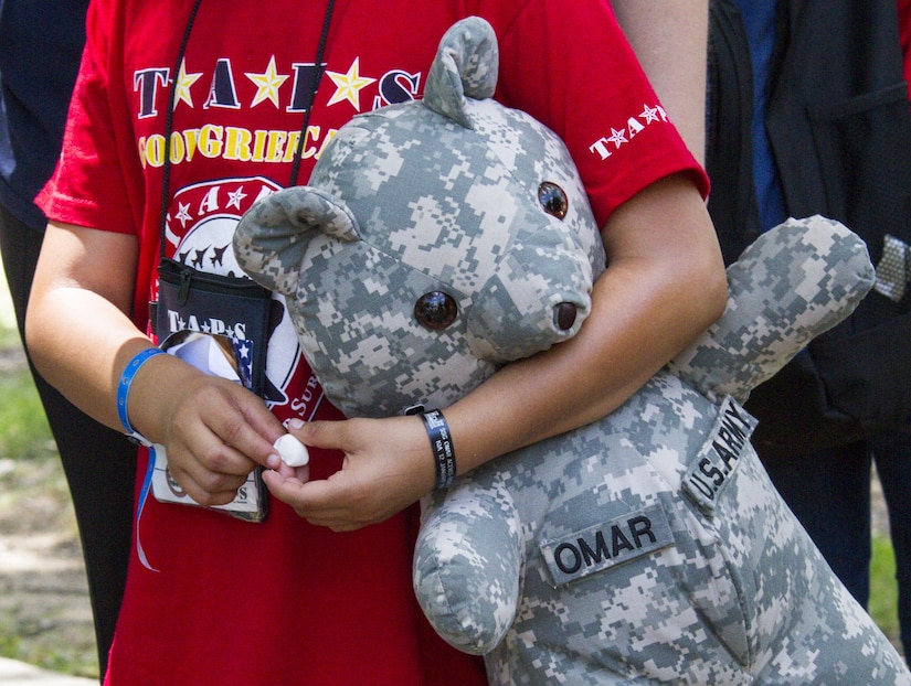 A child carries her teddy bear representing her father who passed away while serving in the Army, during the Tragedy Assistance Program for Survivors (TAPS) National Military Survivors Seminar and Good Grief Camp in Crystal City, Va., on May 29. TAPS is an organization that provides support to people who are affected by the death of a military service member. (U.S. Army photo by Spc. Victoria Friend)