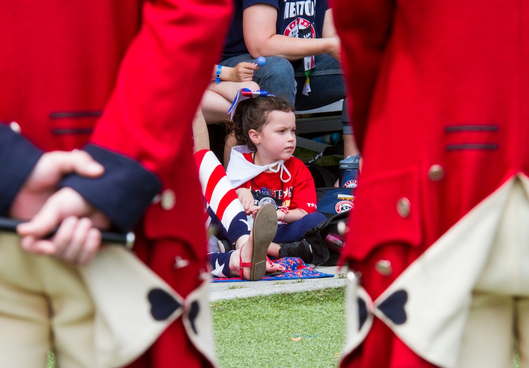 A child looks on as the Old Guard Fife and Drum Corp prepares to perform during the Tragedy Assistance Program for Survivors (TAPS) National Military Survivors Seminar and Good Grief Camp in Crystal City, Va., on May 29. TAPS is an organization that provides support to people who are affected by the death of a military service member. (U.S. Army photo by Spc. Victoria Friend)