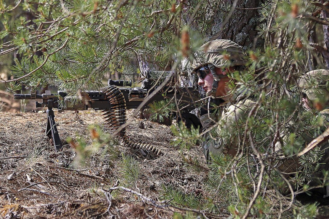 Army Spc. Shane Starliper pulls security in a defensive position with an M240B machine gun before conducting live-fire training at Adazi Military Base, Latvia, June 2, 2016. Soldiers adjusted positions before firing at targets, later advancing on foot and in Stryker armored vehicles. Starliper is an infantryman assigned to 2nd Squadron, 2nd Cavalry Regiment. Army photo by Sgt. Paige Behringer