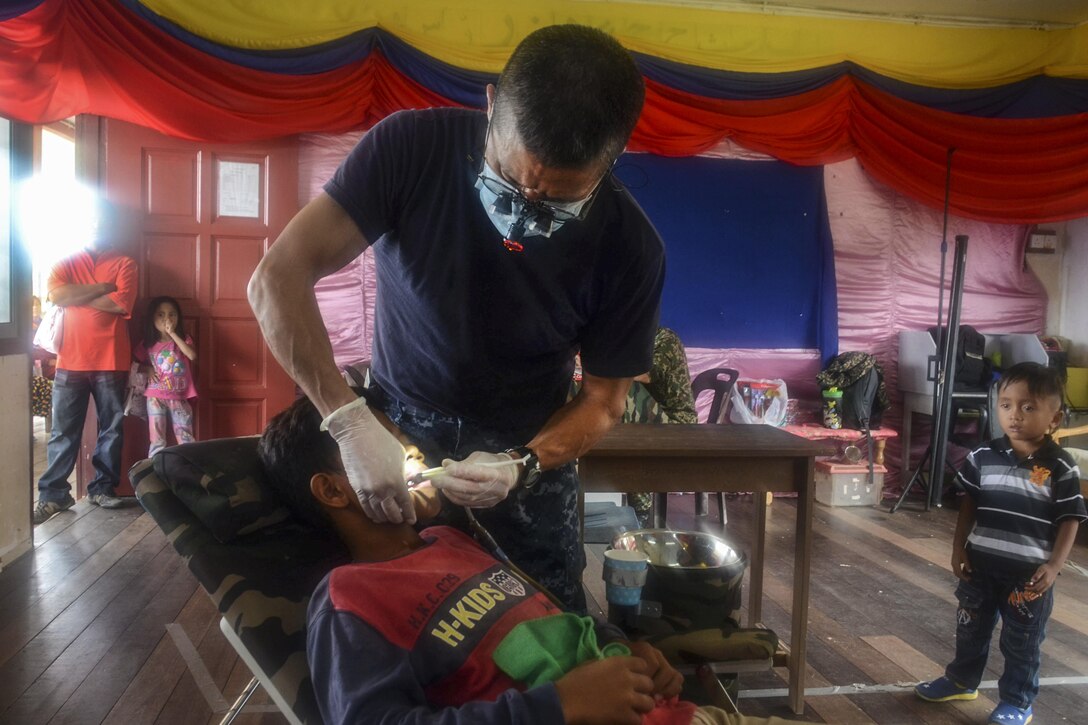 Navy Capt. Loren Masuoka performs an oral examination in Sandakan, Malaysia, June 2, 2016, during Cooperation Afloat Readiness and Training Malaysia 2016. The annual maritime exercises occur among the U.S. Navy, U.S. Marine Corps and the armed forces of nine partner nations, including Bangladesh, Brunei, Cambodia, Indonesia, Malaysia, the Philippines, Singapore, Thailand, and Timor-Leste. Navy photo by Petty Officer 3rd Class Madailein Abbott