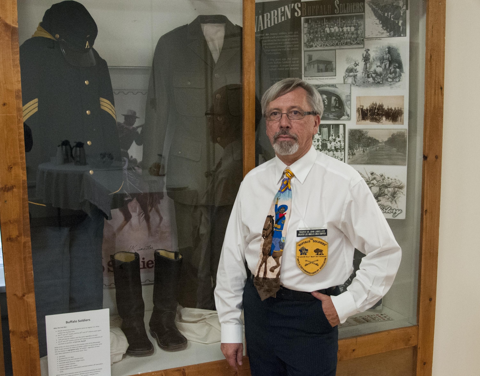 John Langellier, Ph.D., consulting historian, poses in the Warren ICBM & Heritage Museum on F.E. Warren Air Force Base, Wyo., June 1, 2016, in front of a display case housing Buffalo Soldier artifacts such as uniform items and photographs. (U.S. Air Force photo by Senior Airman Jason Wiese)