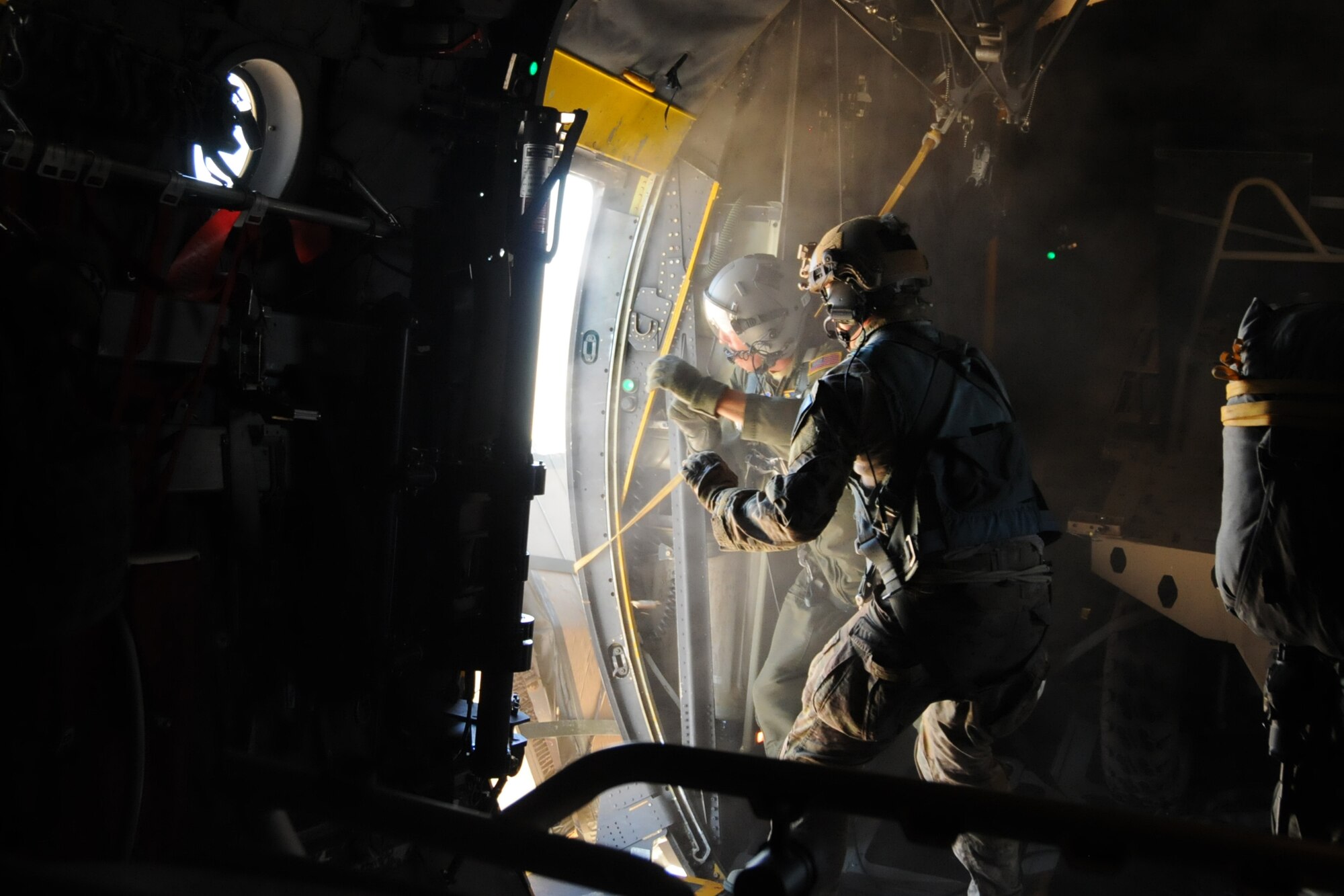 A Special Tactics Airman assists Master Sgt. Anthony Cooper, 700th Airlift Squadron loadmaster, finish dropping a dusty "door bundle" parcel containing a tactical mini-bike from a 94th Airlift Wing C-130 Hercules during an airdrop mission supporting Exercise Eager Lion in Jordan, May 19, 2016. Special Tactics combat controllers jump into hostile and austere areas and use vehicles to set up long airfields for follow-on aircraft and troops. (U.S. Air Force photo/Staff Sgt. Alan Abernethy)
