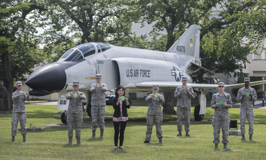 Personnel from the 35th Fighter Wing Public Affairs Office hold green dots, each representing a positive action or behavior, at Misawa Air Base, Japan, June 2, 2016. The non-profit organization, Green Dot, has been awarded a contract by the U.S. Air Force to support its five-year strategy to curb interpersonal violence across the service. Under the terms of the agreement, Green Dot will provide the Air Force with violence prevention tools for a period of three years. (U.S. Air Force photo by Senior Airman Brittany A. Chase)