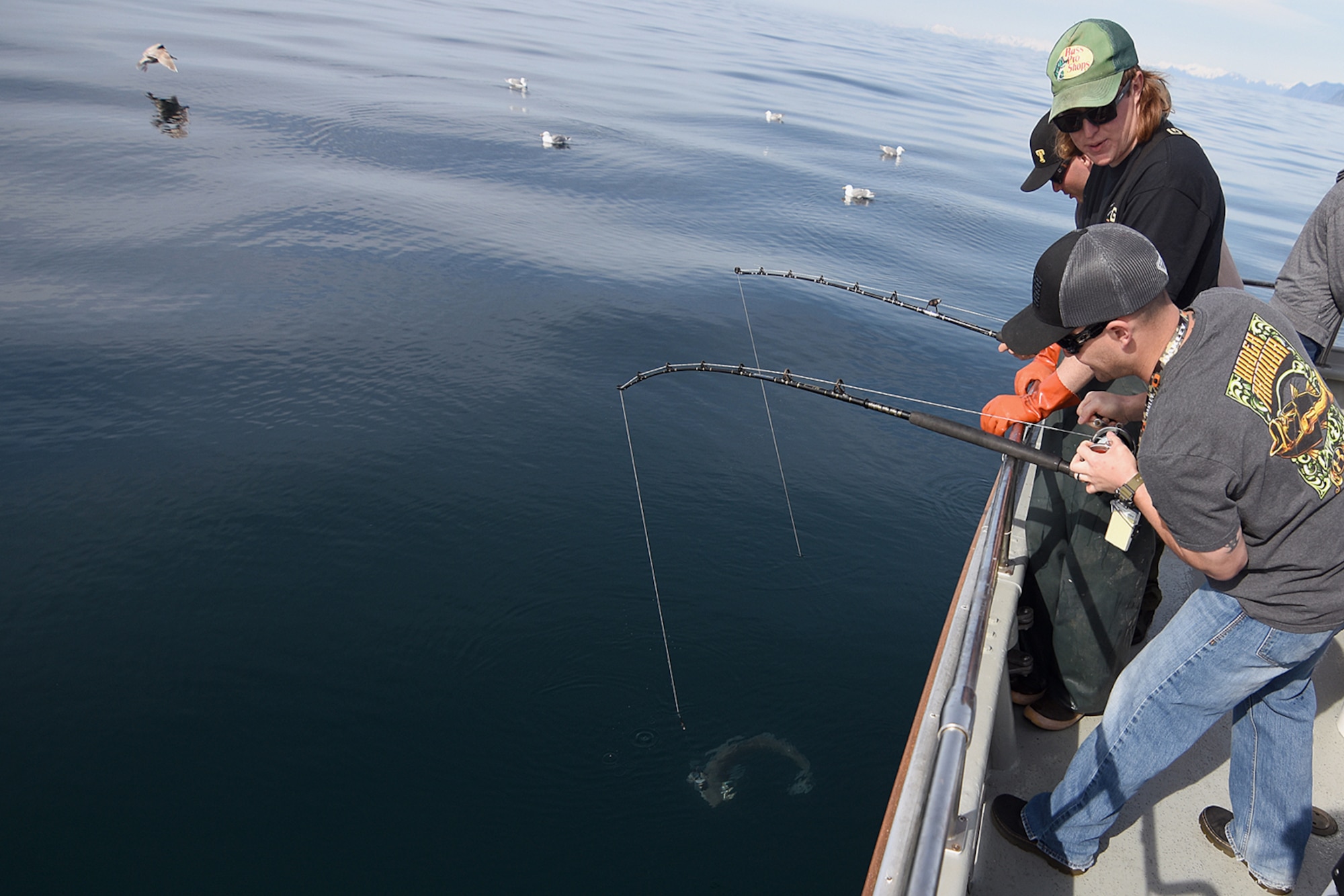 Volunteer deck hand Kyle Collins talks a military angler through landing a spiny dogfish in the 10th Annual Armed Services Combat Fishing Tournament May 26 aboard the Seward Military Resort boat, Snowbird. The tournament, hosted by the city of Seward and the Armed Services YMCA, gave more than 200 military anglers stationed in Alaska a free day of halibut fishing to thank them for their service. (U.S. Army photo by John Pennell)