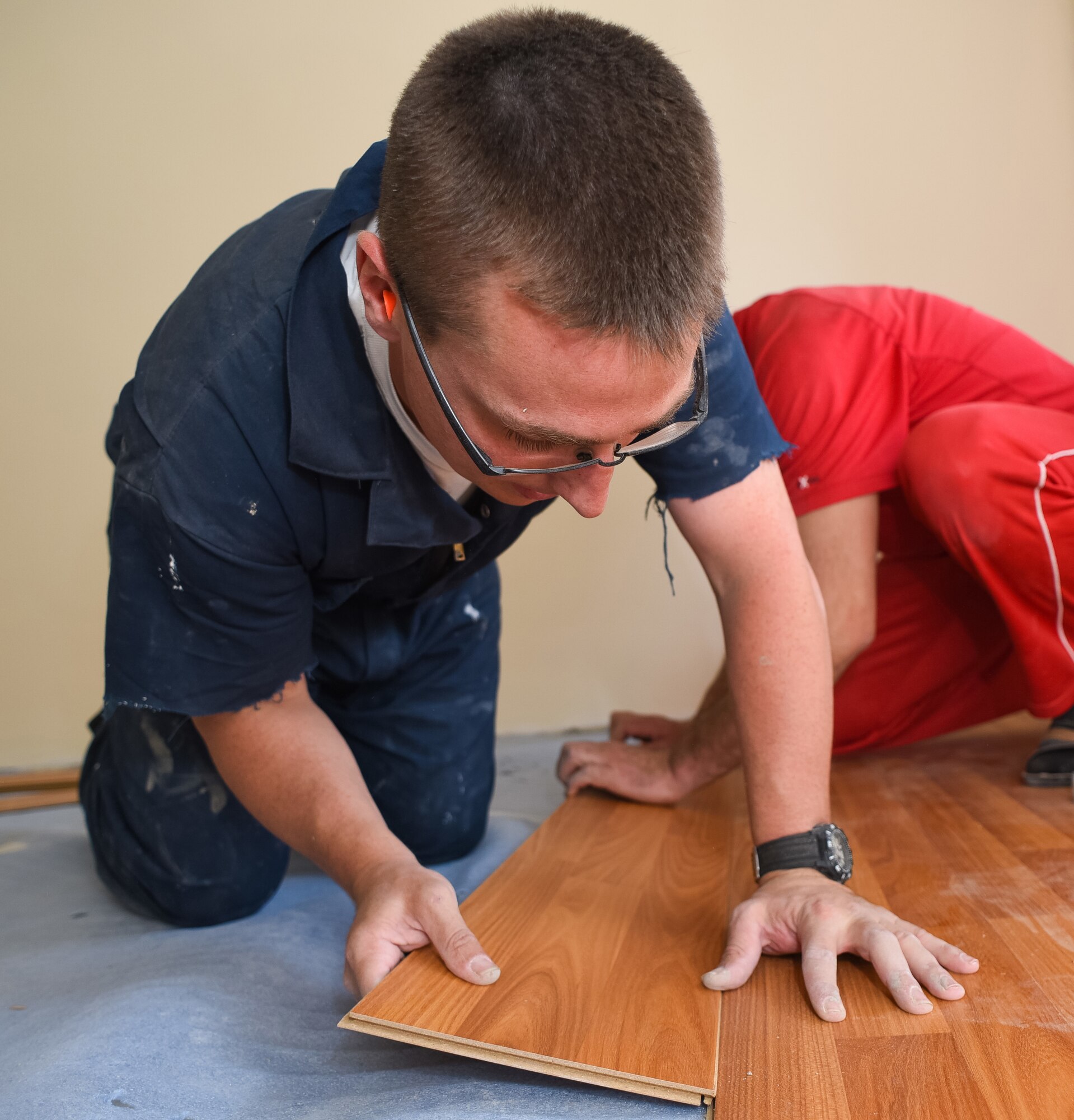Staff Sgt. Aaron Nickell, a 461st Air Control Wing structural craftsman, helps an Armenian contractor install flooring in a newly renovated room at an institute for the elderly during a European Command Humanitarian Civic Assistance project in Yerevan, Armenia, May 22.(U.S. Air Force photo by Senior Master Sgt. Roger Parsons)