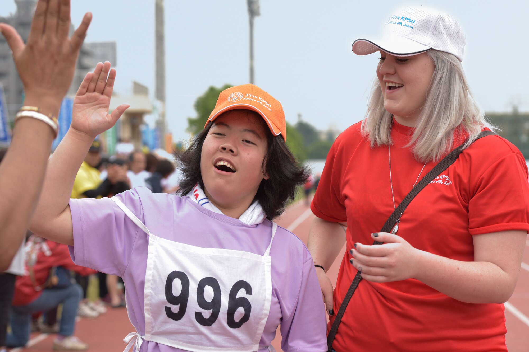 An athlete exchanges a high-five with a spectator after completing the 50-meter sprint during the 37th Annual Kanto Plains Special Olympics held at Yokota Air Base Japan, May 28, 2016. Members of the U.S. Armed Forces, Department of Defense employees, Japanese Self-Defense Force members and Japanese volunteers cheered on athletes throughout the event. (U.S. Air Force photo by Machiko Imai/Released)
